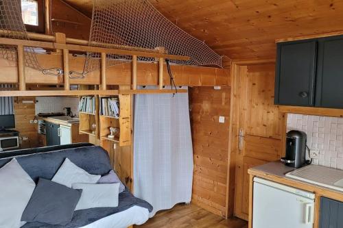 ein Wohnzimmer mit einem Sofa in einer Hütte in der Unterkunft Le Petit Chalet du Chinaillon in Le Grand-Bornand