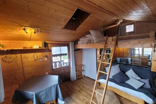 a bedroom with bunk beds in a wooden cabin at Le Petit Chalet du Chinaillon in Le Grand-Bornand