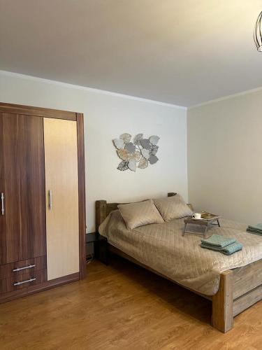 Un dormitorio con una cama con una mesa. en DZIRNAVU IELAS APARTMENT, en Kuldīga