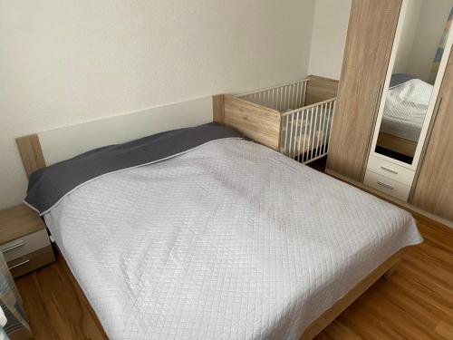 um pequeno quarto com uma cama e um espelho em Ferienwohnung em Emmingen-Liptingen