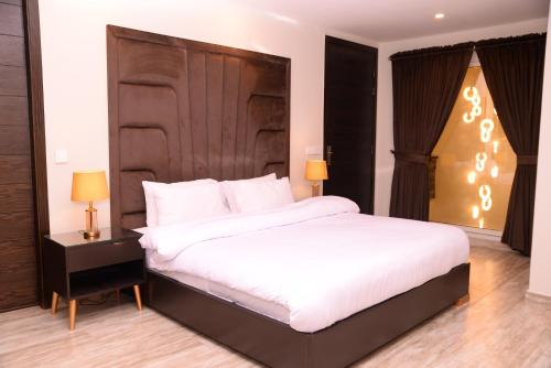 a bedroom with a large bed with a large wooden headboard at Tom's Luxury in Peshawar