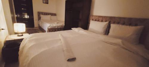 - un grand lit blanc dans une chambre d'hôtel dans l'établissement Carpet Alaadein Pyramids view, au Caire