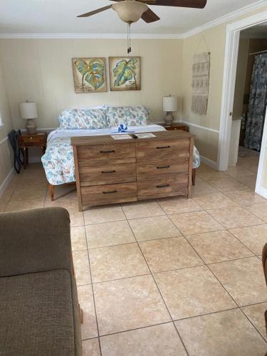 a bedroom with a bed and a wooden dresser at Pirates Pointe Resort in Ruskin