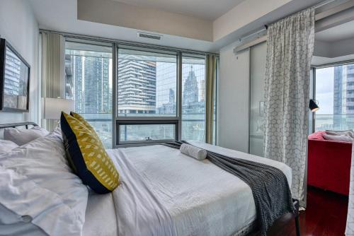 een slaapkamer met een bed en een groot raam bij Downtown Apartments 16 in Toronto