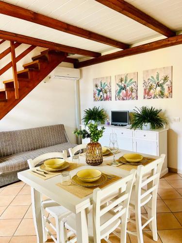 una sala da pranzo con tavolo e sedie bianchi di La Casa di Gió in Centro a Olbia