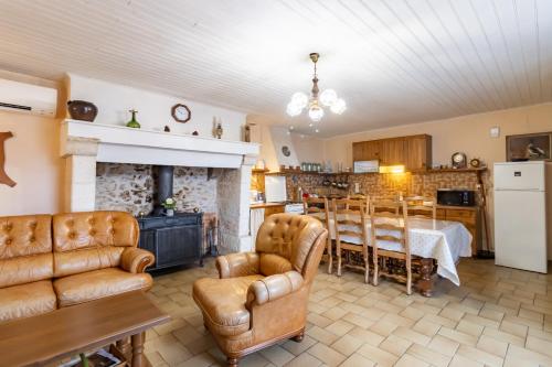 - un salon avec une cheminée, une table et des chaises dans l'établissement Le haut Picot, à Bussac