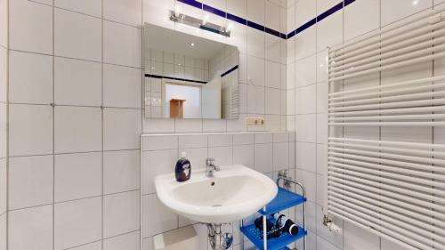 a white bathroom with a sink and a mirror at Haus Saxonia in Binz