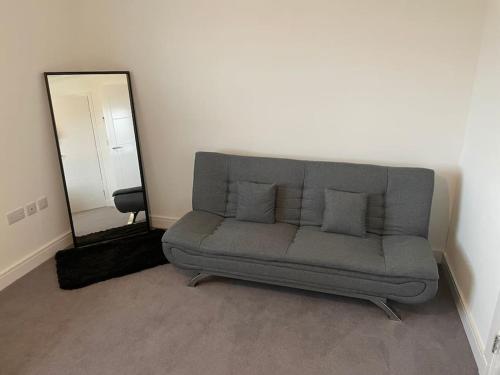 a couch in a living room with a mirror at Modern 2 Bedroom House, Edinburgh. in Millerhill