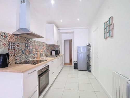  La cuisine est équipée de placards blancs et d'un réfrigérateur. dans l'établissement ღ Les Jumeaux - Charmant cocon au cœur de Toulouse, à Toulouse