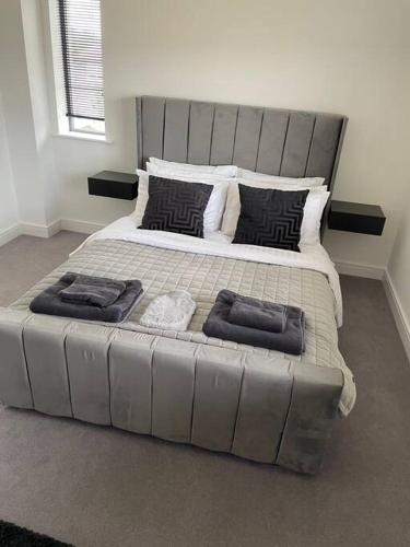 a large bed with two pillows on it in a bedroom at Modern 2 Bedroom House, Edinburgh. in Millerhill