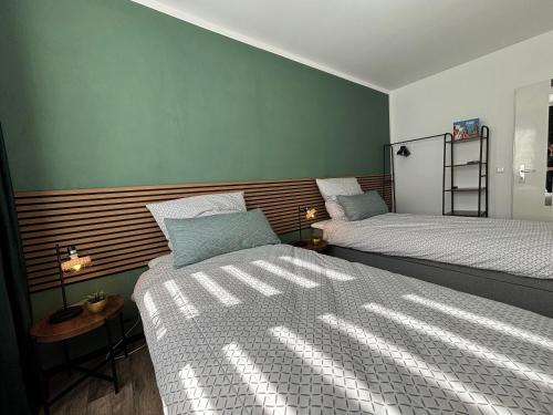 two beds in a room with green walls at Business- Apartment Worms # guesthouse- Monteure willkommen in Worms