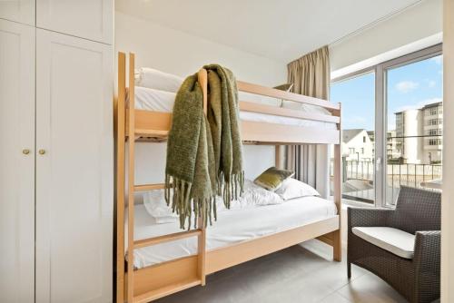 a bedroom with bunk beds with a balcony at Huswell - Apartment with natural swimming pool in Middelkerke