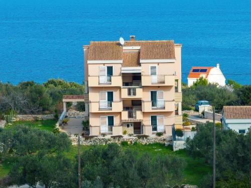 an apartment building with the ocean in the background at Apartman Sipina 2 in Kukljica