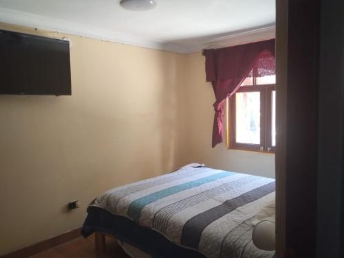 a small bedroom with a bed and a window at Casa Abuelito's Andean Haven in Huaraz