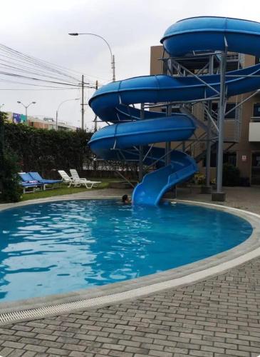 a person in a swimming pool with a water slide at departamento de 1 dormitorio in Lima