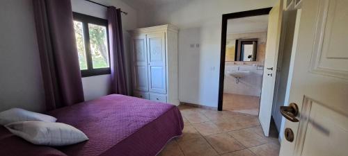 a bedroom with a bed and a bathroom with a sink at GardenRocks in Fluminimaggiore