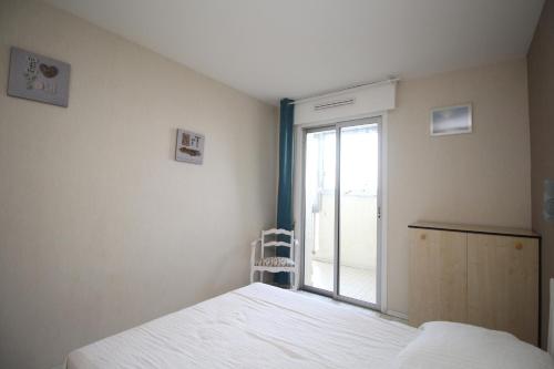 une chambre avec un lit blanc et une fenêtre dans l'établissement Appartement 4 personnes vue mer avec parking, à Canet