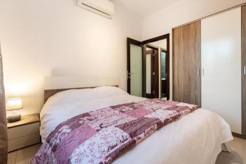 a bedroom with a bed with a pink blanket on it at A Bright & Lovely 2 Bedroom Apartment 1 minute walk from promenade apartment 3 in Il-Gżira