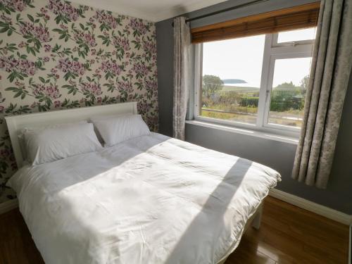 una camera con un letto bianco e una finestra di Oileainan a Achill