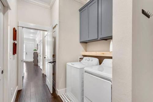 a laundry room with white cabinets and a washer and dryer at Harribo Townhome - Walk Everywhere - Downtown Fay in Fayetteville