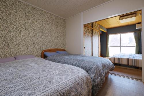 a bedroom with two beds and a window at Quilotoa Mifune Guesthouse in Mifune