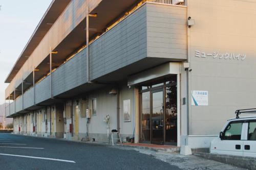 a building with a parking lot with a car parked outside at Quilotoa Mifune Guesthouse in Mifune