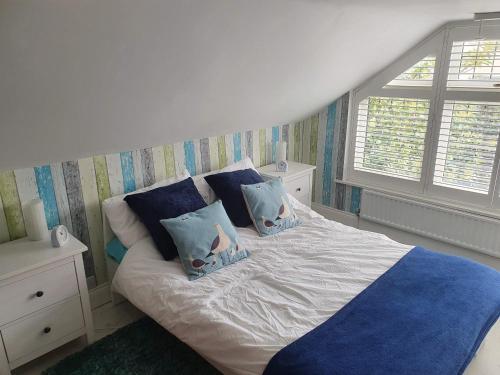 a bed with two pillows on it in a bedroom at Bournemouth secluded cottage 10mins walk to beach in Bournemouth