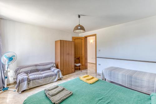 sypialnia z 2 łóżkami i wentylatorem w obiekcie Casa Puzzedde w mieście Castrignano del Capo