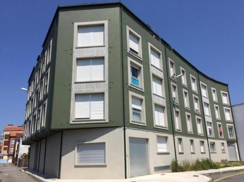 un edificio verde e bianco sul lato di una strada di Apartamento a estrenar en A Pobra do Caramiñal a A Pobra do Caramiñal