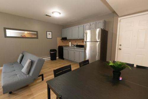 a kitchen and dining room with a table and a refrigerator at Mins to NYC! Urban Oasis 2-BR home with King & Queen Beds in Jersey City