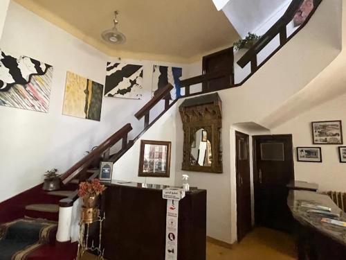 una sala de estar con una escalera de caracol en una casa en Hôtel El Ayachi en Midelt
