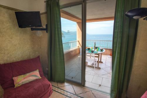 a room with a balcony with a view of the ocean at Résidence Villa Nova in Tiuccia