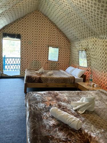 卡齊蘭加的住宿－Kodom Bari Retreat, Kaziranga，酒店客房带两张床和两个窗户
