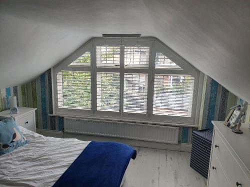 a bedroom with a bed and a large window at Bournemouth secluded cottage 10mins walk to beach in Bournemouth