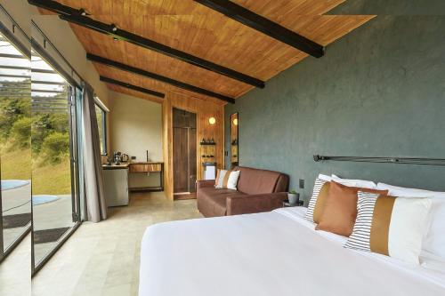 a bedroom with a bed and a living room at Fuga Neusa in Tausa Viejo