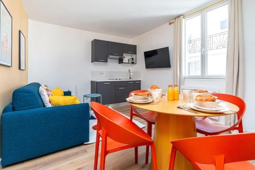 un salon avec une table et un canapé bleu dans l'établissement Havre de Paix près de la Capitale, à Bagnolet