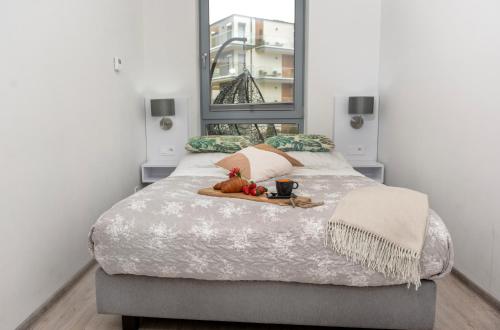 a bedroom with a bed with a tray of food on it at Grunwaldzka 12 A4 Easy-Rent Apartments - 50m od plaży z dużym tarasem in Pobierowo