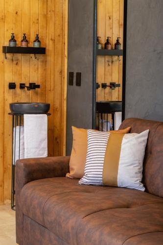 a brown couch with a striped pillow on it at Fuga Neusa in Tausa Viejo