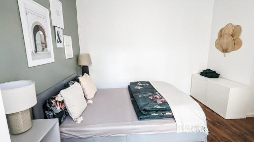 a bed in a room with a white wall at Leipzig Residenz City-Center Apartments in Leipzig