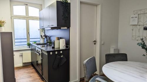 a small kitchen with a black counter and a table at Leipzig Residenz City-Center Apartments in Leipzig