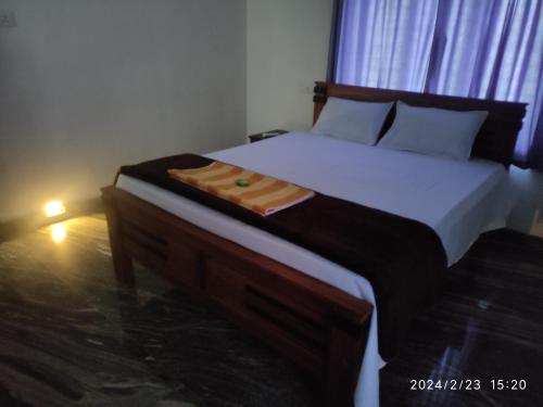 1 dormitorio con 1 cama grande con marco de madera en Mount River Homestay, en Palakkad