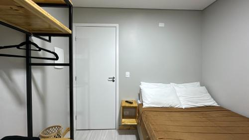 a bedroom with a bunk bed and a white wall at 21- Studio com decoração linda in Curitiba