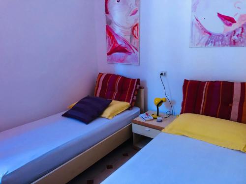 a bedroom with two beds and a night stand with a lamp at Appartamenti "LE CASETTE DI TERESA" in Ortona