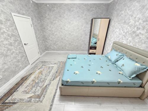 Schlafzimmer mit einem Bett und einem Spiegel in der Unterkunft Sapar apartments 92 in Aqtöbe