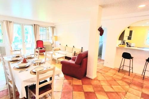 een woonkamer met een tafel en een rode stoel bij Un brin de paille in Cagnes-sur-Mer