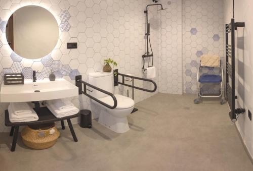 een badkamer met een wastafel, een toilet en een spiegel bij Apartamento Adaptado Andrea 
