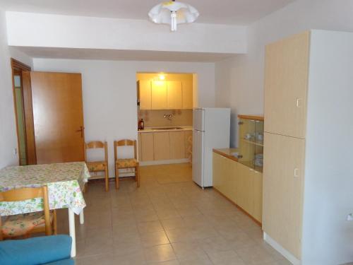een keuken met een tafel en een koelkast bij Appartamenti "LE CASETTE DI TERESA" in Ortona