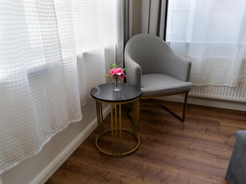 a chair and a table with a vase of flowers on it at Boutique Hotel in Bad Salzuflen