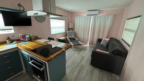 uma pequena sala de estar com um sofá e uma cozinha em Flamingo Tiny Home em Sarasota