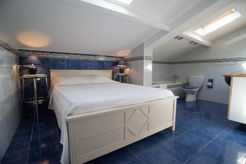 a bedroom with a large bed and a bathroom at Résidence Villa Nova in Tiuccia